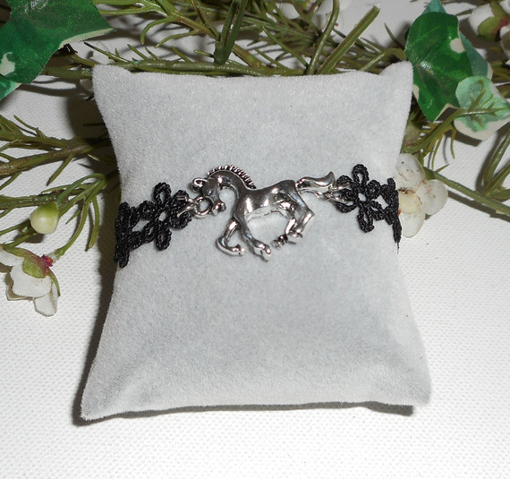 Originele armband met zilverkleurig metalen paard op zwart kant