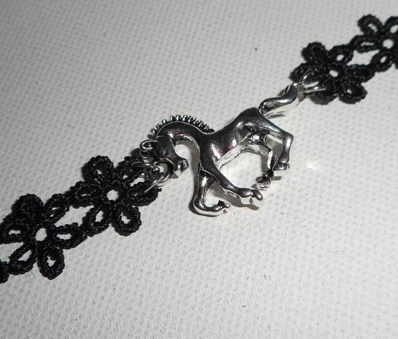 Originele armband met zilverkleurig metalen paard op zwart kant