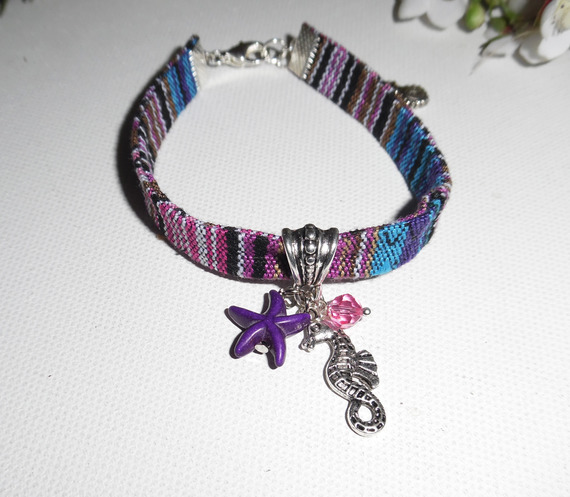 Kleurrijke stoffen armband met kwastjes van zeepaardjes en paarse zeesterren