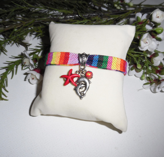 Kleurrijke stoffen armband met dolfijn en rode zeesterren kwastjes
