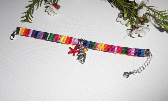 Kleurrijke stoffen armband met dolfijn en rode zeesterren kwastjes