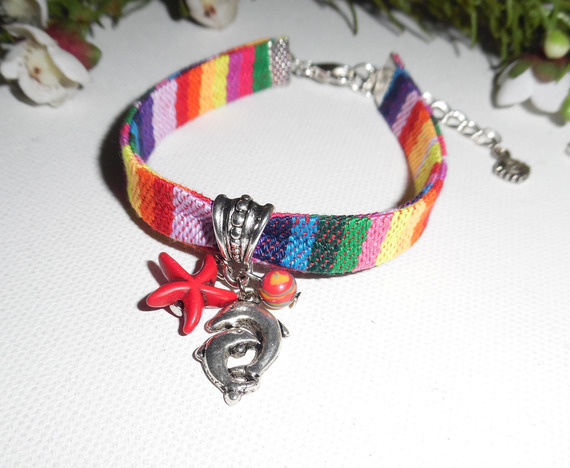 Kleurrijke stoffen armband met dolfijn en rode zeesterren kwastjes