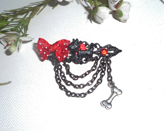 Broche van zwart en rood hars met strikje en zwarte ketting