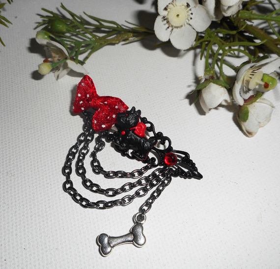 Broche van zwart en rood hars met strikje en zwarte ketting