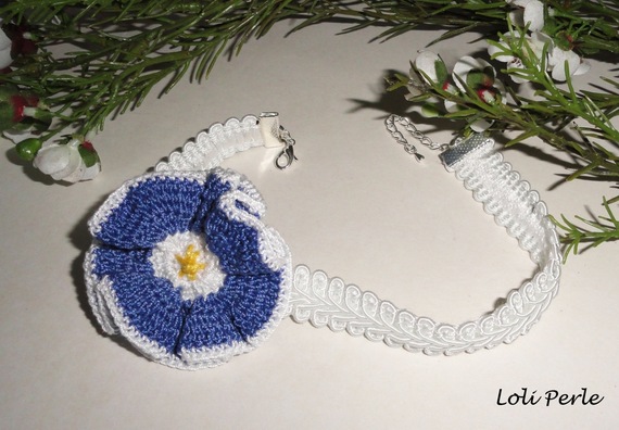 Blauwe bloemenketting op wit siervlechtwerk