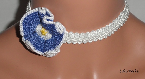 Blauwe bloemenketting op wit siervlechtwerk
