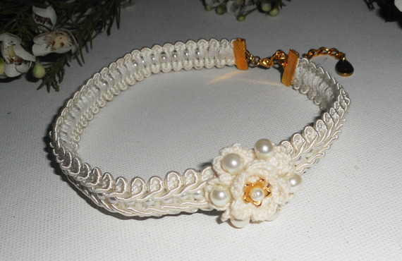 Ecru bloemenketting aan een fancy geborduurde vlecht met glazen kralen