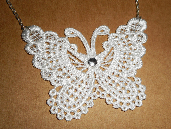Witte vlinderketting in fijn borduurwerk aan zilveren ketting