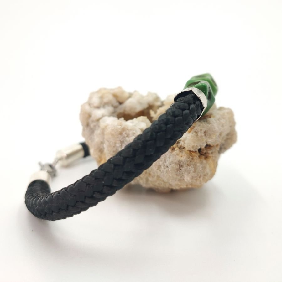 Dubbele schedel en gekruiste botten armband met groene stenen op zwart touw