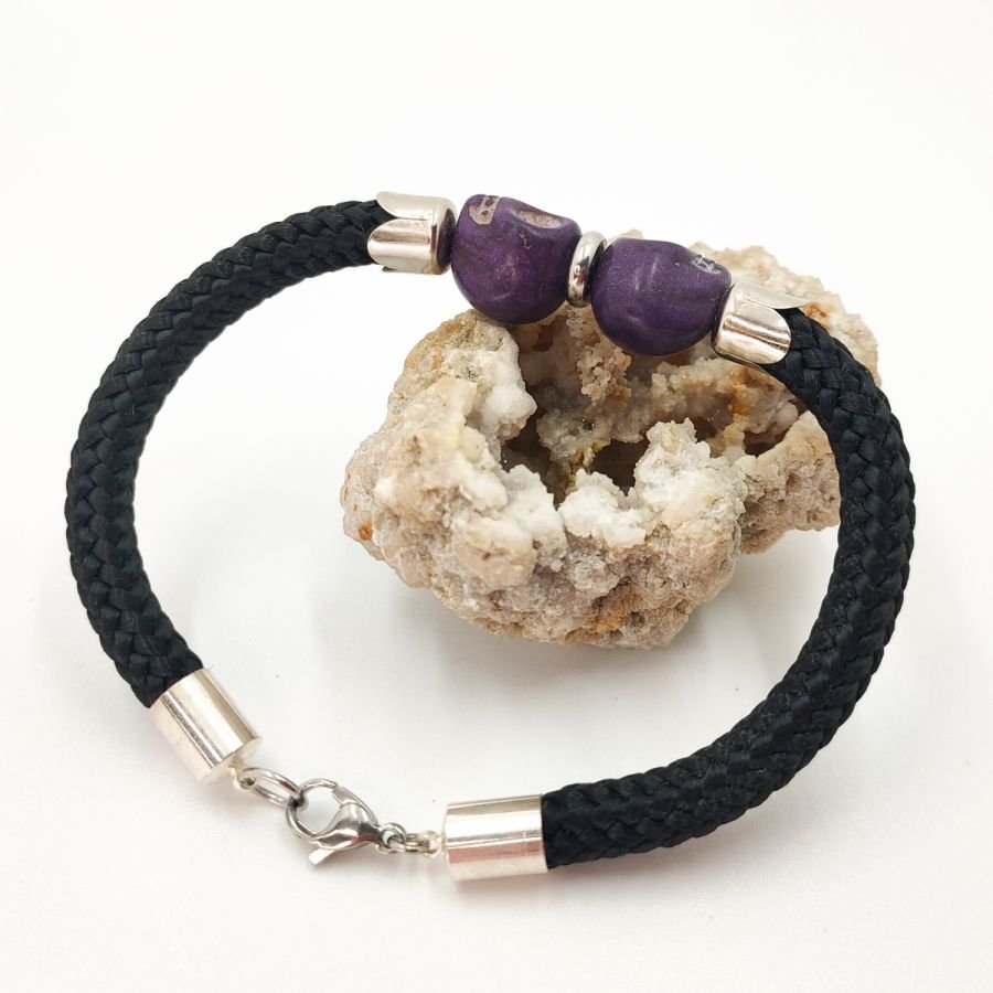 Dubbele schedel en gekruiste botten armband met paarse stenen op zwart touw
