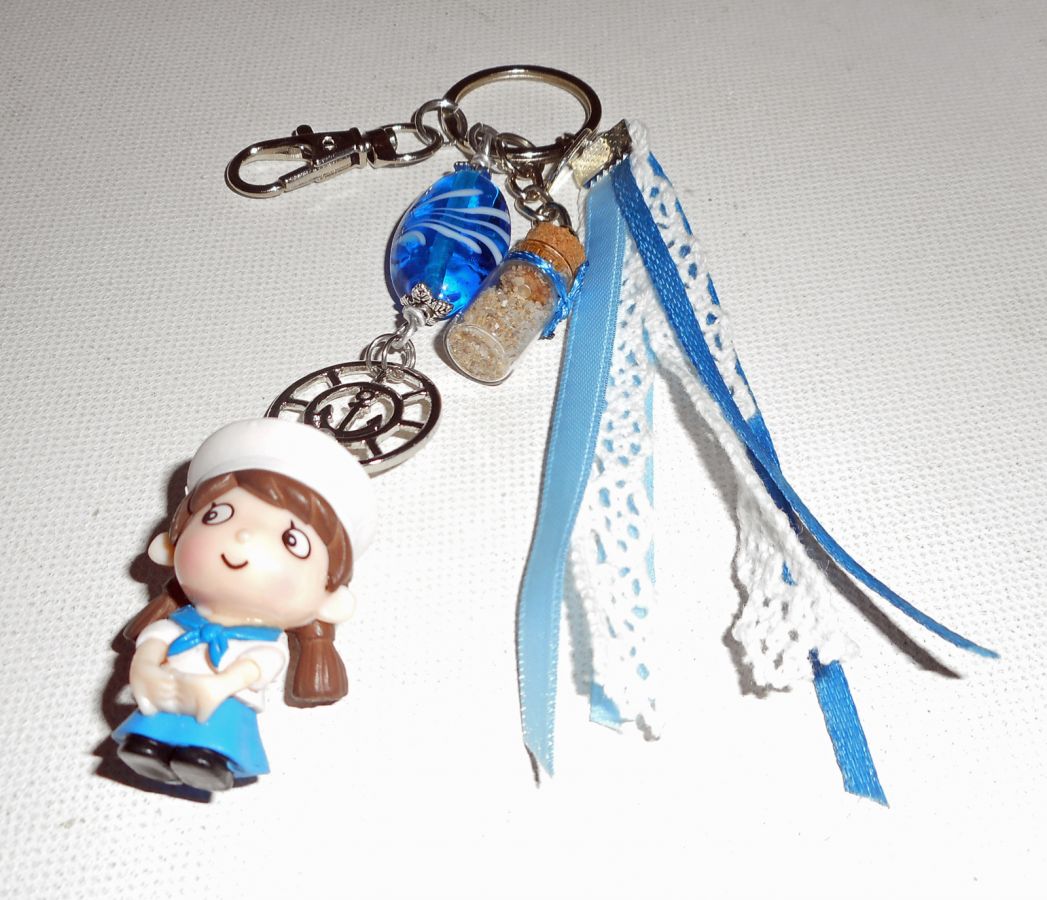 Sleutelhanger/tasjuwelen blauwe glaskraal en kleine zeeman met linten 