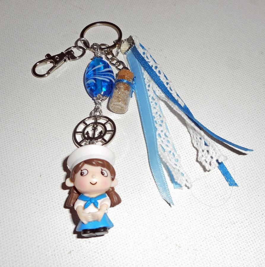 Sleutelhanger/tasjuwelen blauwe glaskraal en kleine zeeman met linten 