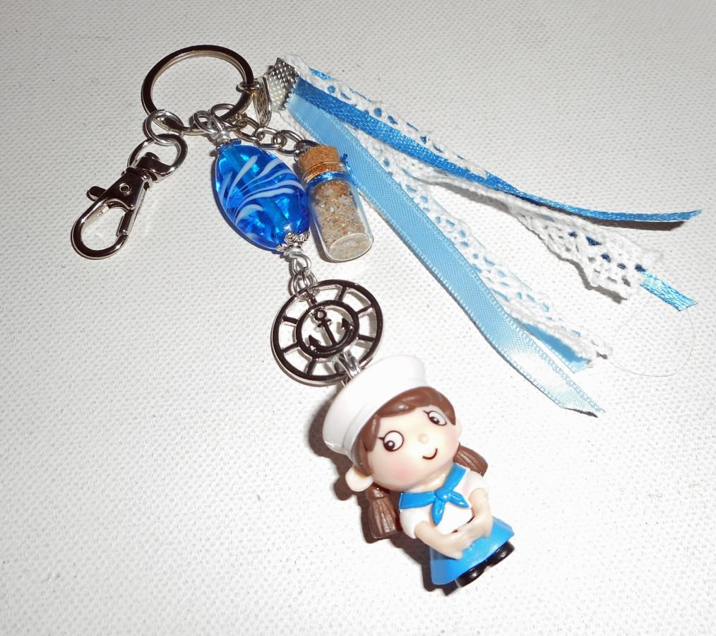 Sleutelhanger/tasjuwelen blauwe glaskraal en kleine zeeman met linten 