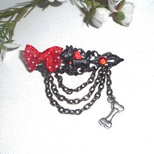 Broche van zwart en rood hars met strikje en zwarte ketting