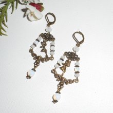 Fee en witte kristallen kwast oorbellen op bronzen dwarsliggers
