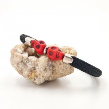 Dubbele schedel en gekruiste botten armband met rode stenen op een dik zwart koord